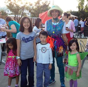 Denise posing with 4 children at a company picnic