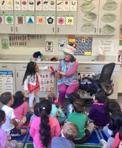Children's entertainer Denise asks a girl to help during her Magic Comedy Show at a preschool birthday party.