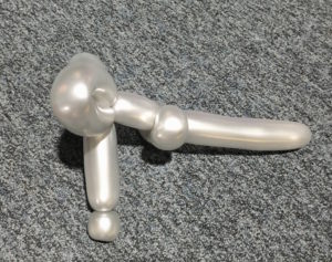 a white balloon twisted into the shape of a gun