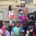 Children's entertainer Denise opens the magic pan during her Magic Comedy Show at a preschool birthday party.